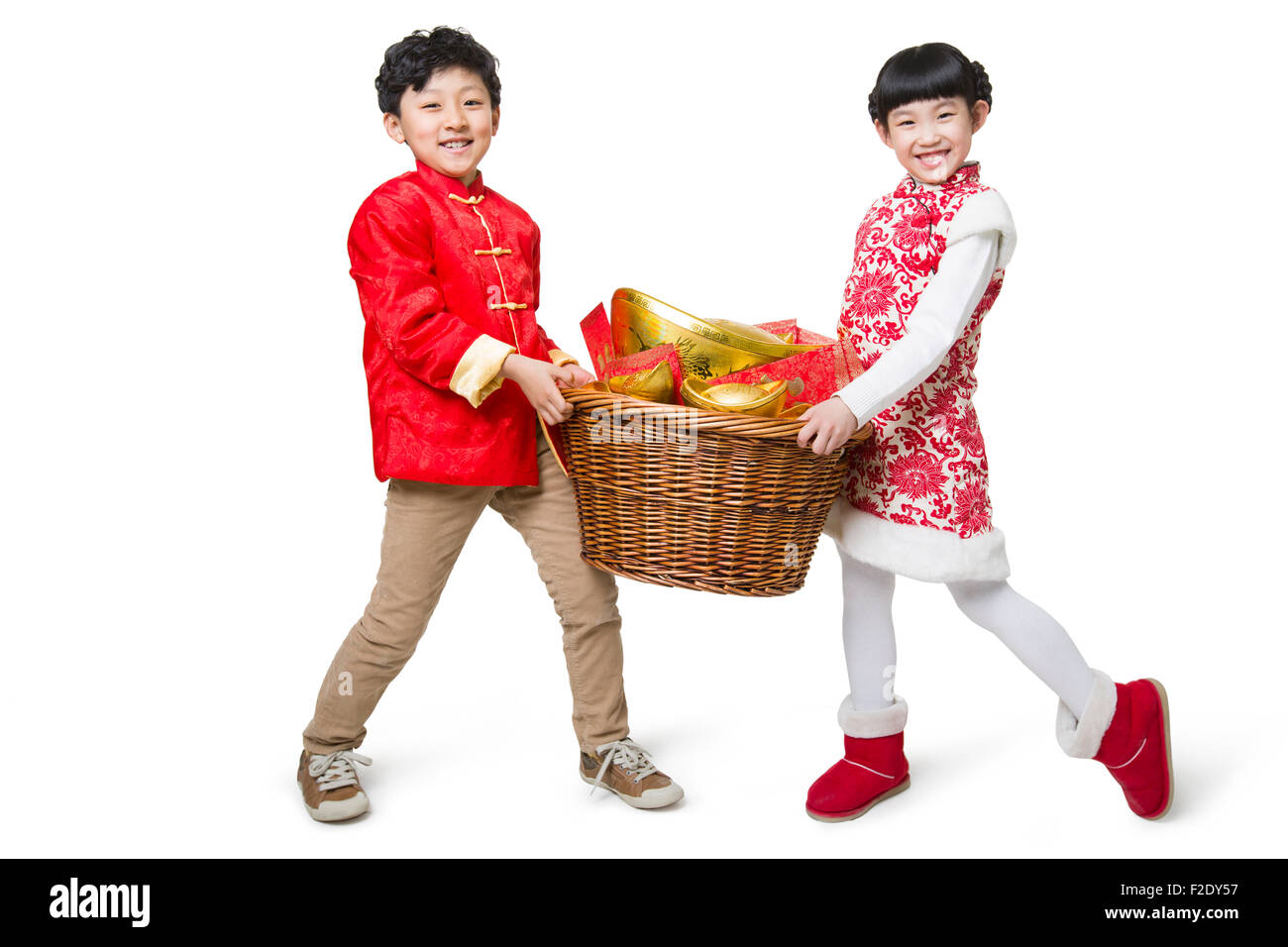 Glückliche Kinder tragen rote Umschläge und chinesische traditionelle Währung Yuanbao Stockfoto