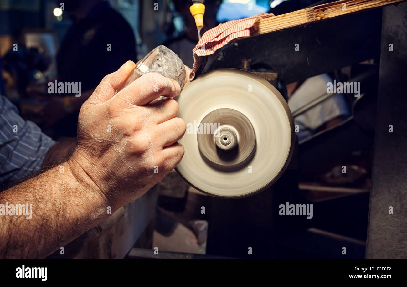 Nahaufnahme der Hände des Handwerkers beim Schleifen von einer Kristall-Aschenbecher Stockfoto