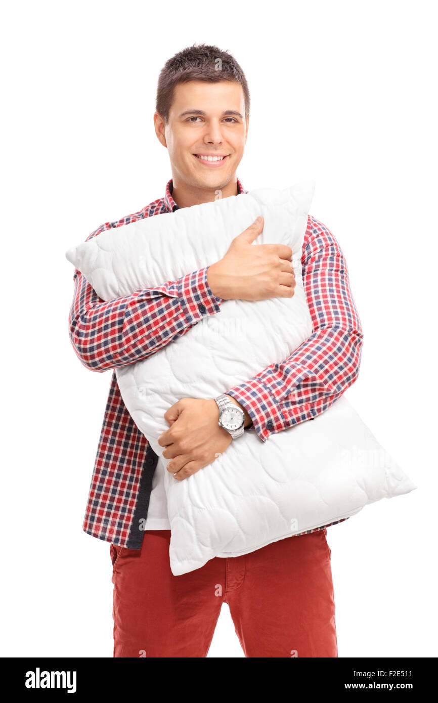 Vertikale Aufnahme von Inhalten junger Mann umarmt eine weißen Kissen und schaut in die Kamera, die isoliert auf weißem Hintergrund Stockfoto