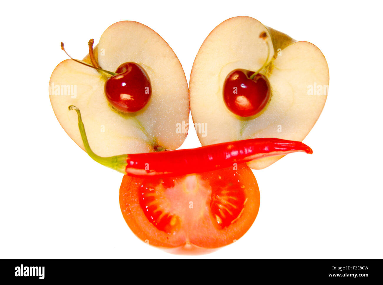 On / Gesicht: Kirschen, Apfel, Tomate, Chilly - Symbolbild Nahrungsmittel. Stockfoto