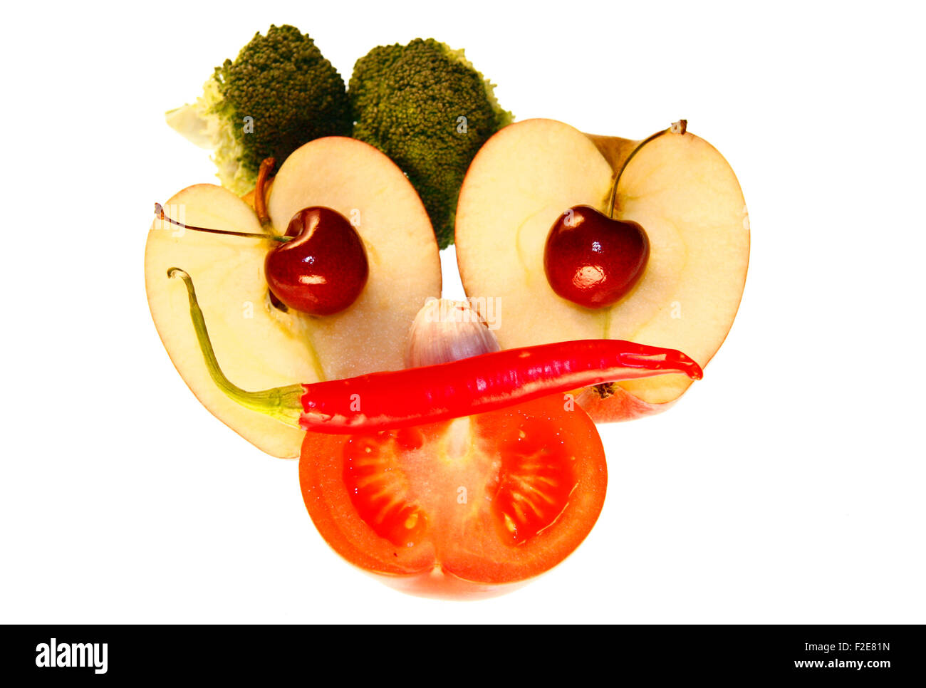 On / Gesicht: Kirschen, Apfel, Tomate, Brokkoli, Chilly - Symbolbild Nahrungsmittel. Stockfoto