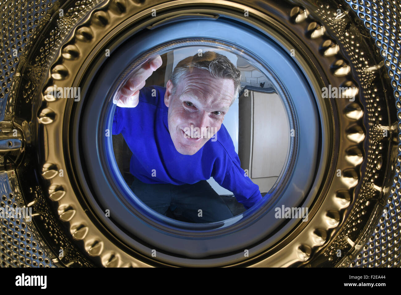 Mann unter der Waschmaschine auswaschen Stockfoto