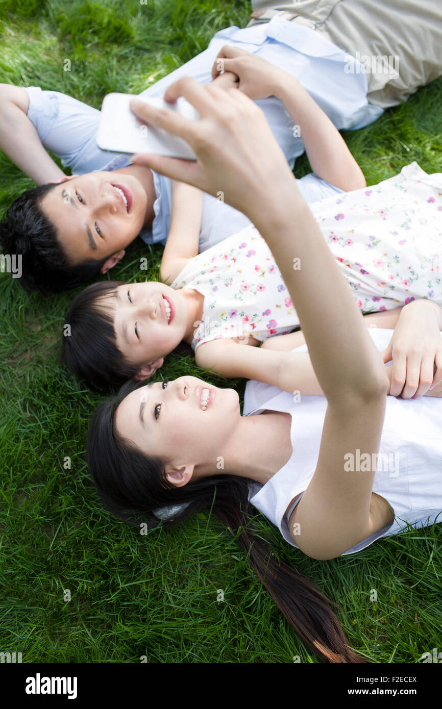 Glückliche junge Familie liegen auf dem Rasen Stockfoto