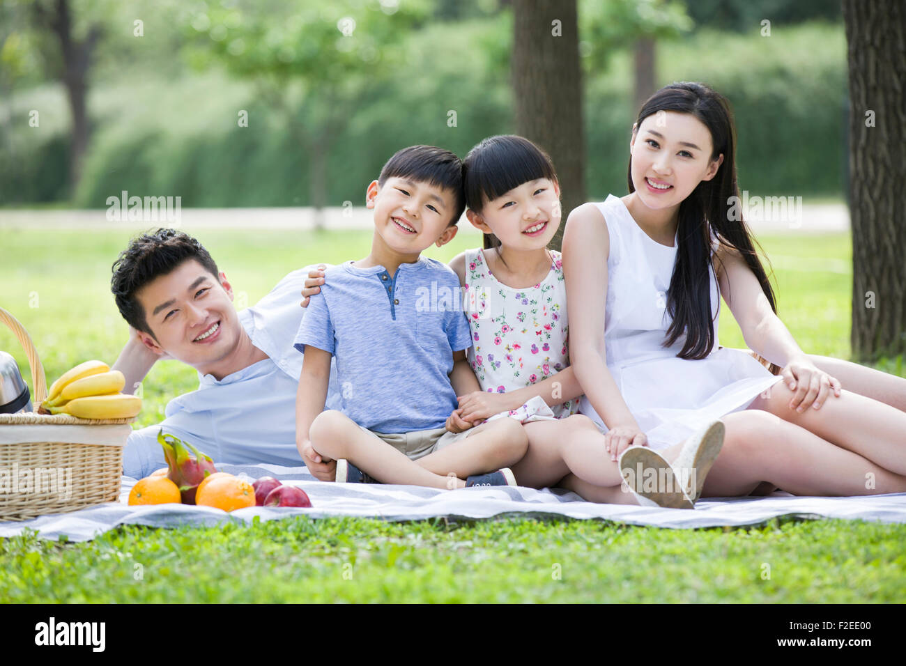 Glückliche junge Familie Picknick auf dem Rasen Stockfoto