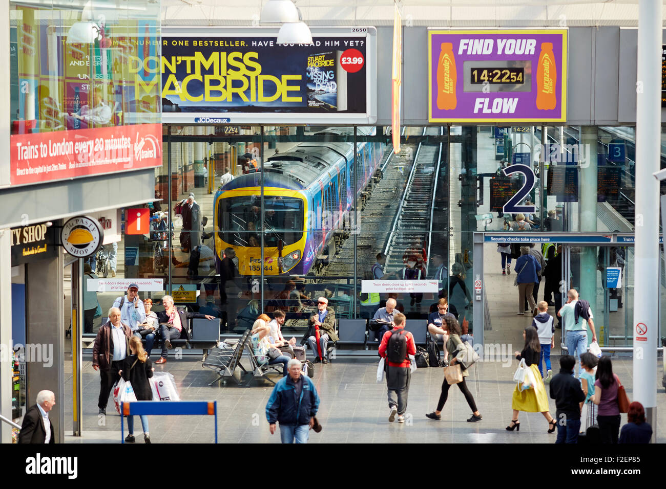 Manchester Piccadilly Station Bahnfahrgäste in der Bahnhofshalle mit He-Zug durch er sichtbar Glas Passagiere vorbei an P Stockfoto