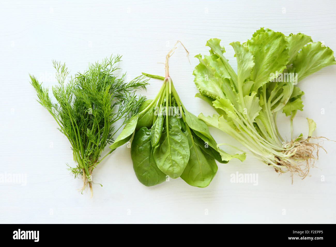 Dill, Spinat und Salat auf weißem Holz Hintergrund, Essen Stockfoto