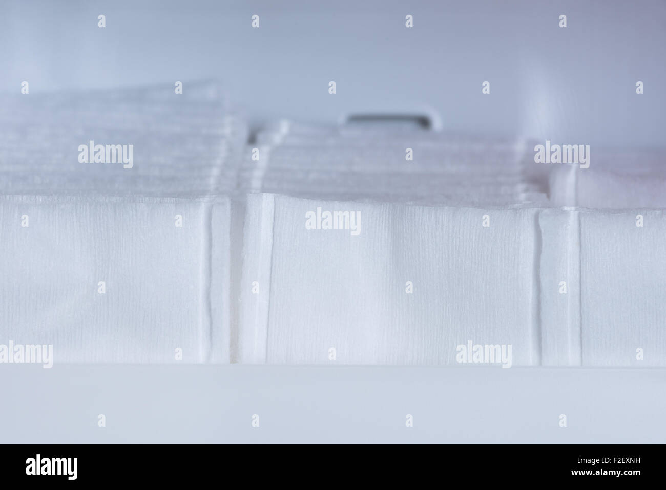 Eine Makroaufnahme des weißen Wattestäbchen aufgereiht in einem Badezimmer-Schrank-Regal. Stockfoto