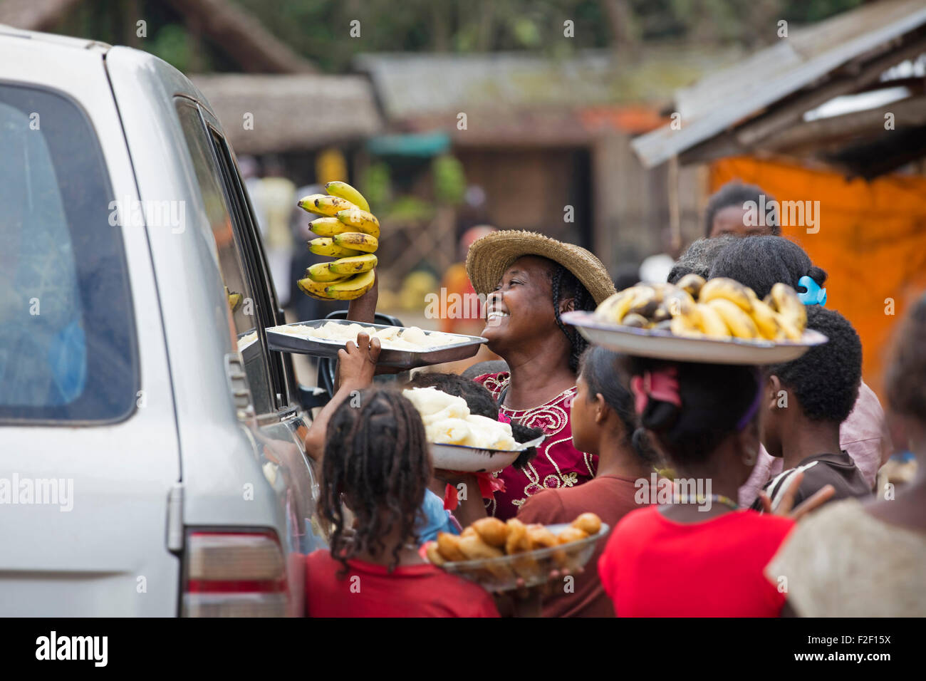 Lokalen madagassischen Frauen verkaufen Bananen und Lebensmittel an Passanten im Fahrzeug in ländlichen Dorf in Madagaskar, Afrika Reisen Stockfoto