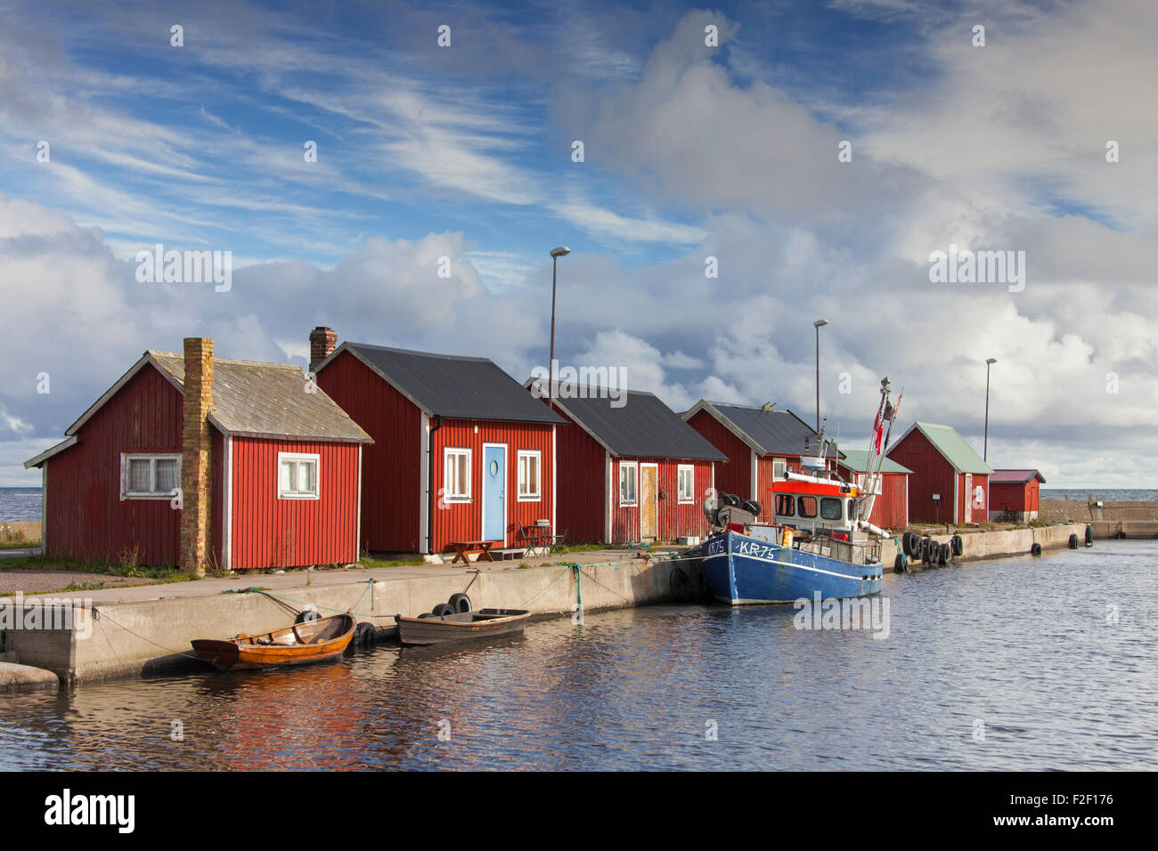 Rote Fischerhütten Rorbuer Kabinen und Angeln Boot im Hafen von Graesgard / / Gräsgård, Öland, Schweden Stockfoto