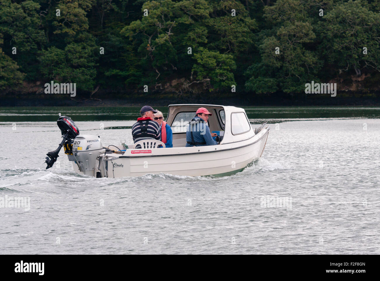 3 Personen In einem kleinen Boot mit Außenbordmotor auf dem Fluß Truro Cornwall England UK Stockfoto