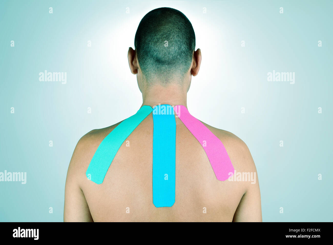 Nahaufnahme eines jungen Mannes mit einigen Klebestreifen elastische therapeutische verschiedener Farben in den Rücken Stockfoto