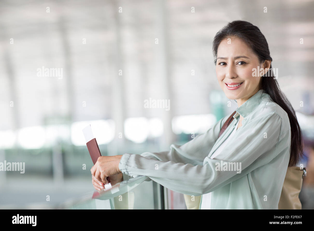 Reife Frau wartet am Flughafen Stockfoto