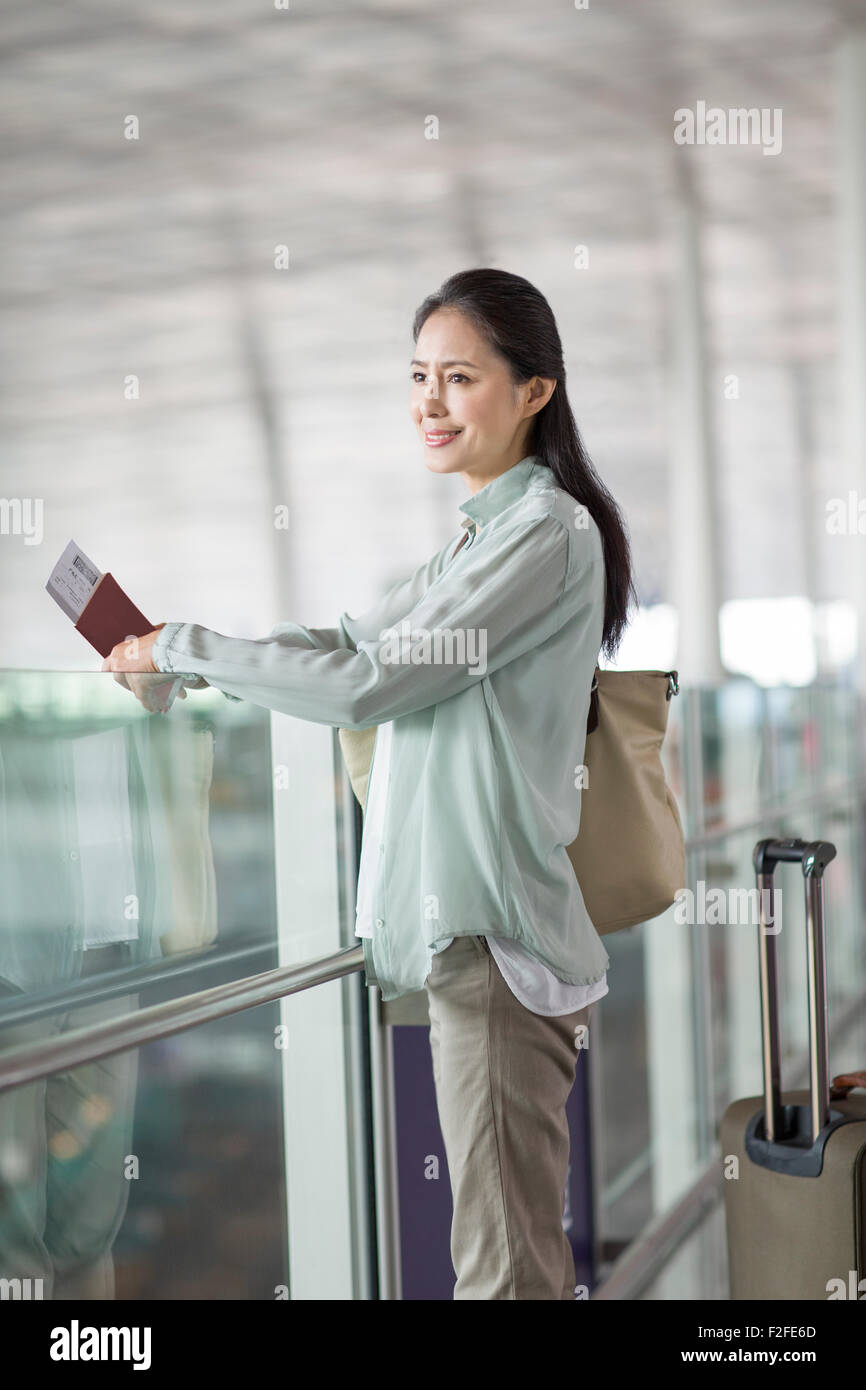 Reife Frau wartet am Flughafen Stockfoto
