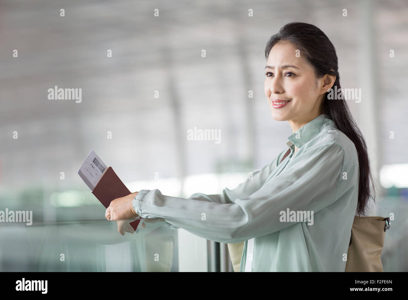 Reife Frau wartet am Flughafen Stockfoto