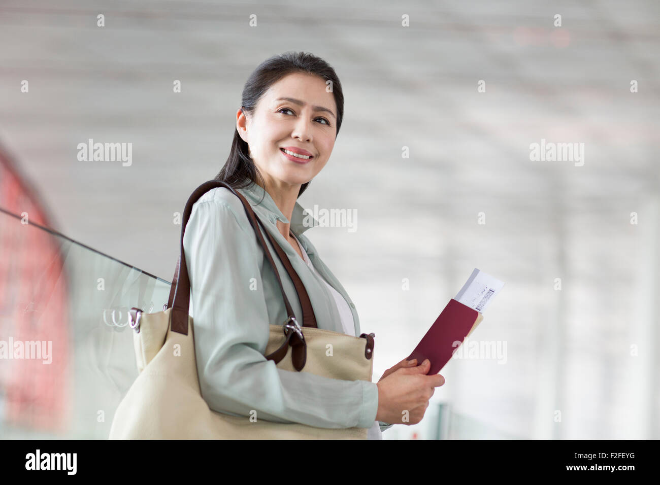 Reife Frau wartet am Flughafen Stockfoto