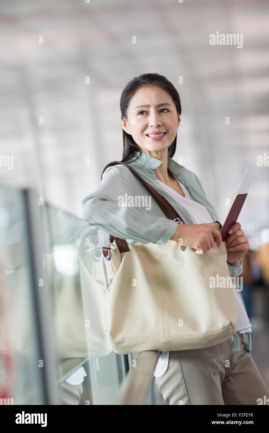 Reife Frau wartet am Flughafen Stockfoto