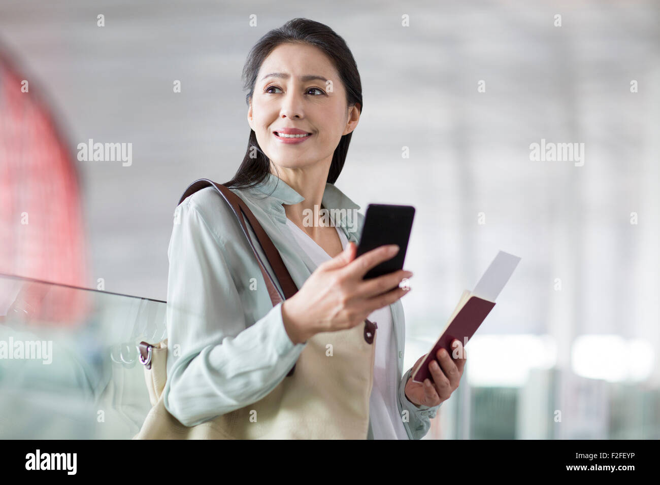 Reife Frau wartet am Flughafen Stockfoto