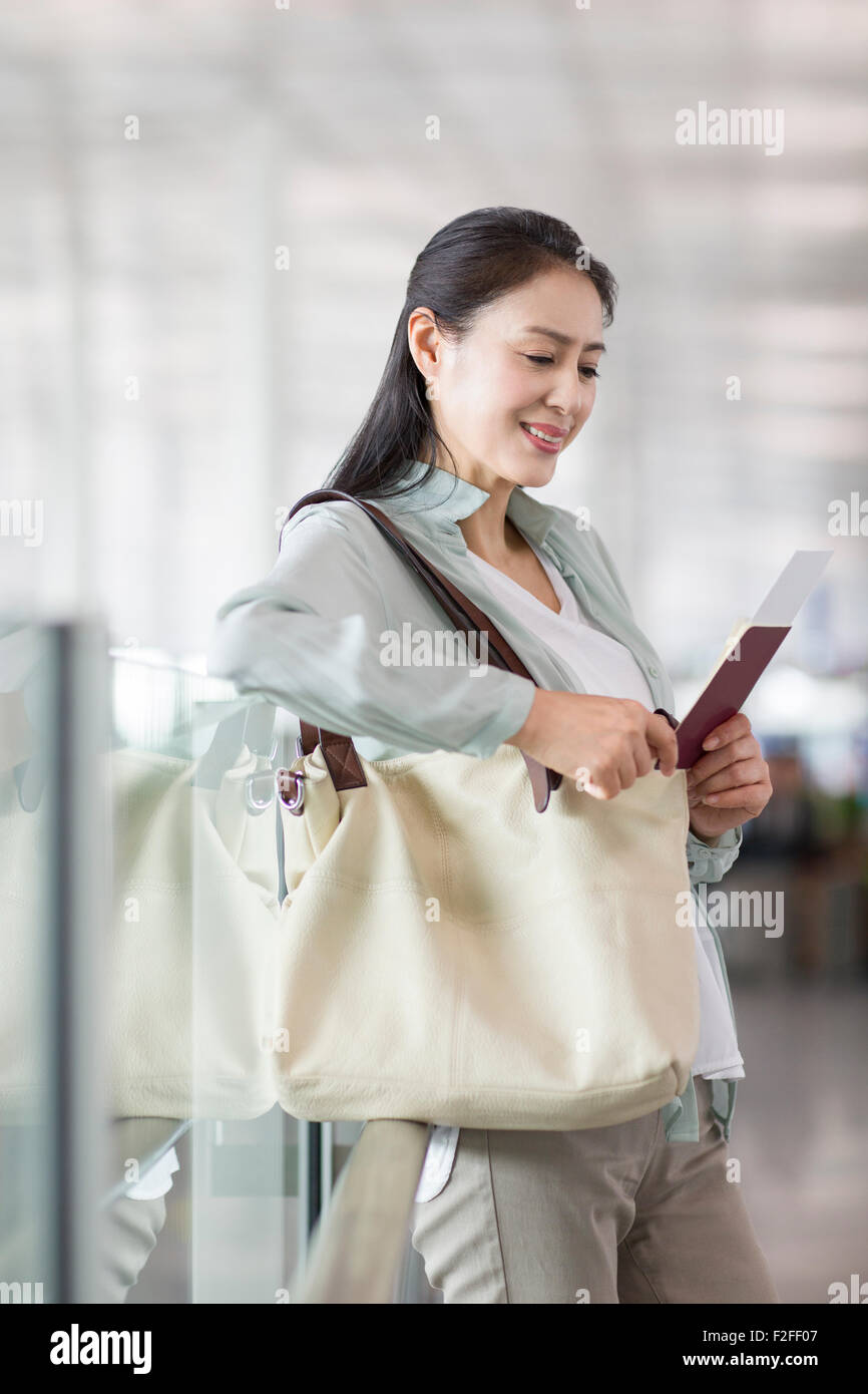 Reife Frau wartet am Flughafen Stockfoto
