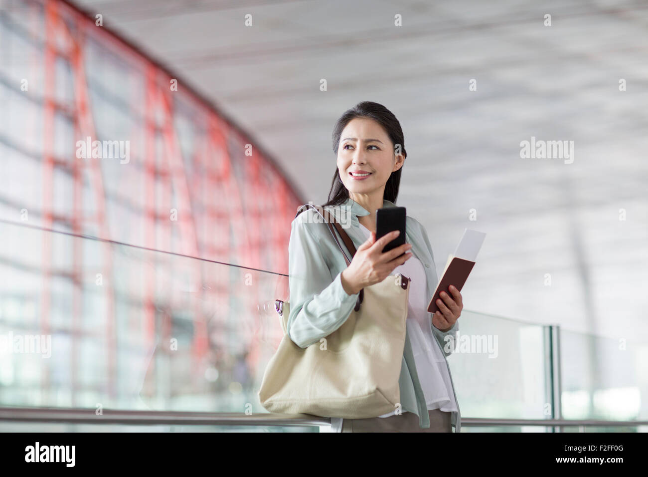 Reife Frau wartet am Flughafen Stockfoto