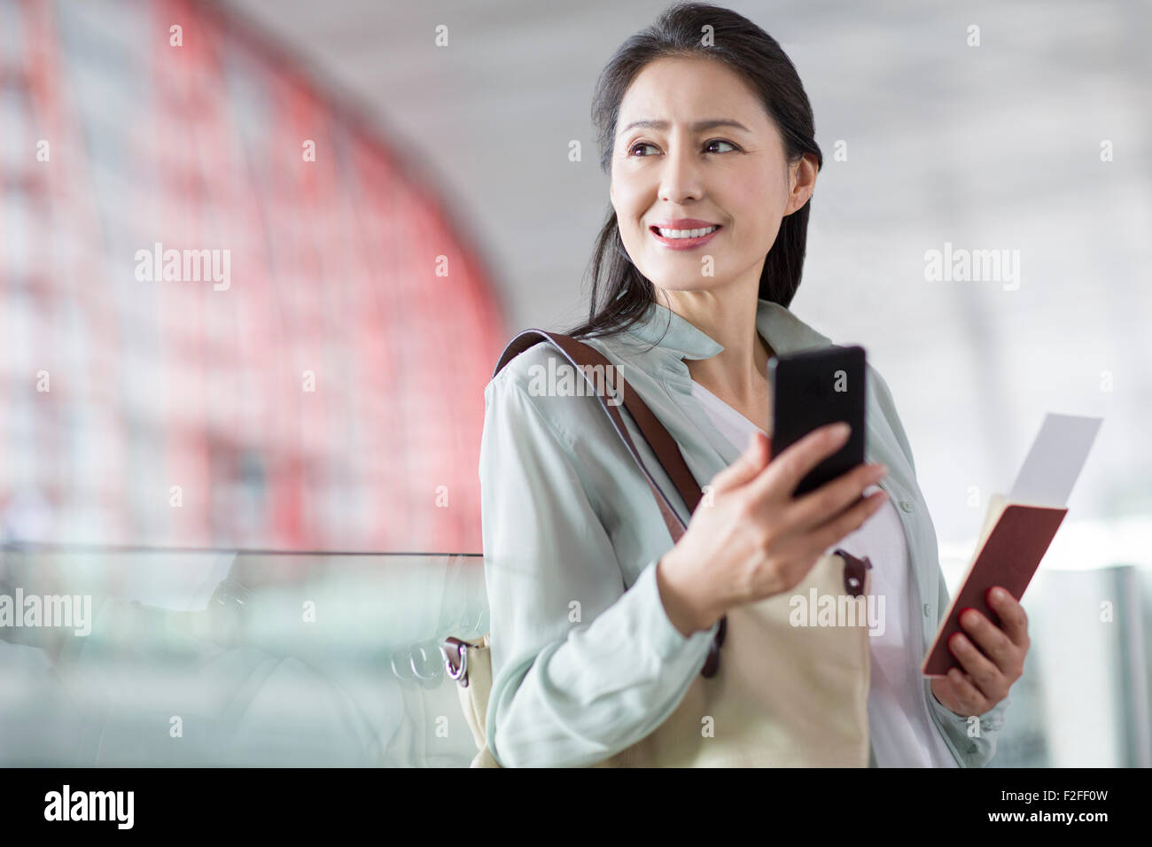 Reife Frau wartet am Flughafen Stockfoto