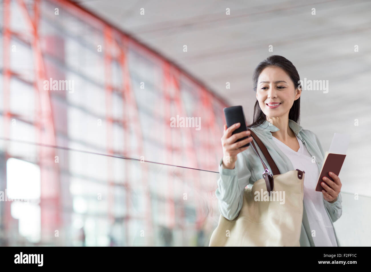 Reife Frau wartet am Flughafen Stockfoto