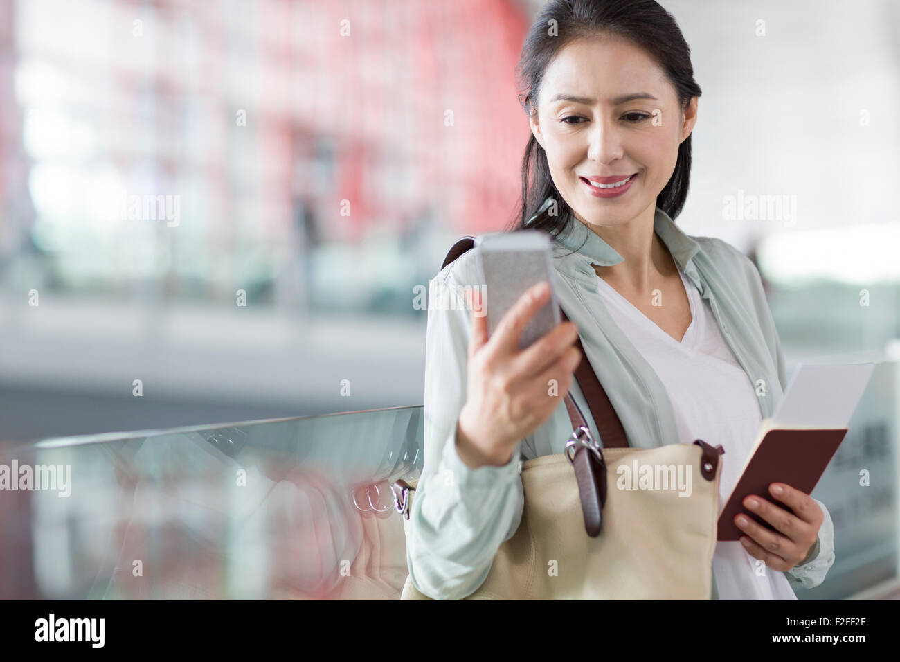 Reife Frau wartet am Flughafen Stockfoto