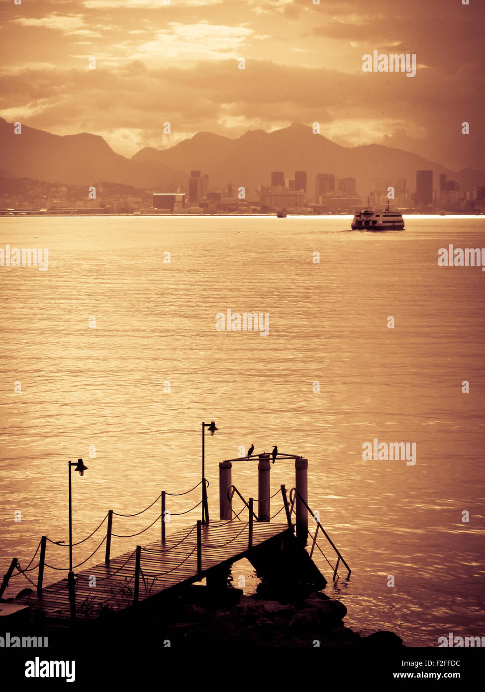 Goldener Sonnenuntergang über der Skyline der Stadt Rio De Janeiro mit Pier im Vordergrund, Brasilien. Stockfoto