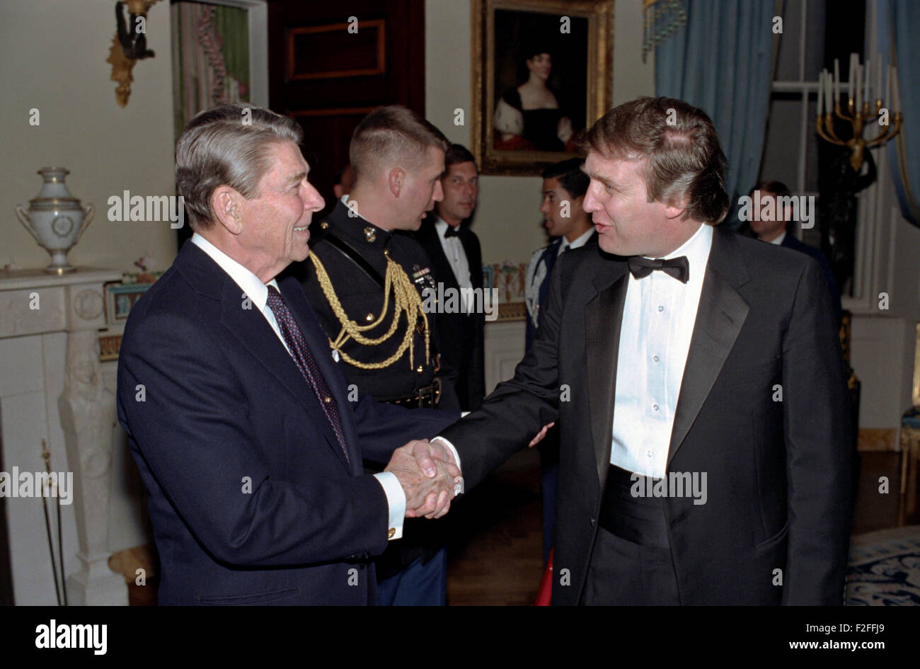 US-Präsident Ronald Reagan grüßt Milliardär Entwickler Donald Trump bei einem Empfang für die Mitglieder der Stiftung "Freunde von Kunst und Konservierung in Botschaften" im Blue Room des weißen Hauses 3. November 1987 in Washington, DC. Stockfoto
