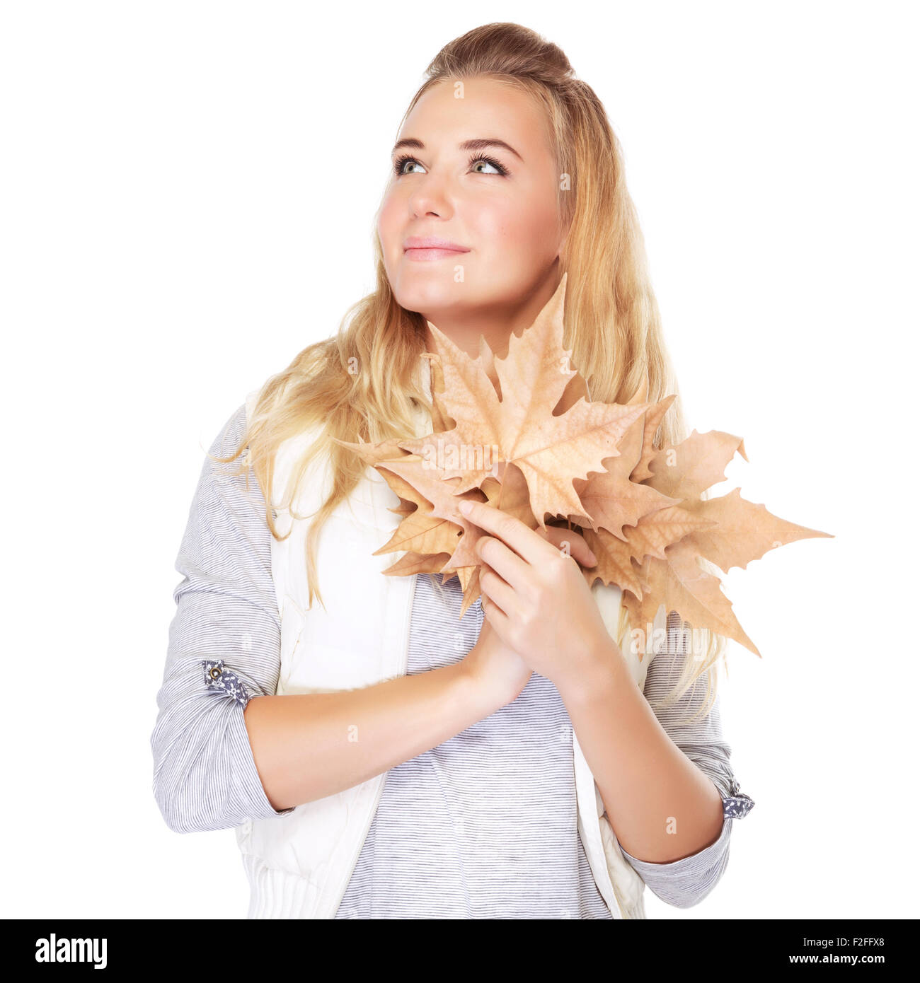 Porträt von niedlichen verträumte Mädchen mit trockenen Blättern Strauß in Händen, die auf der Suche auf einer Seite isoliert auf weißem Hintergrund, Herbst Stockfoto