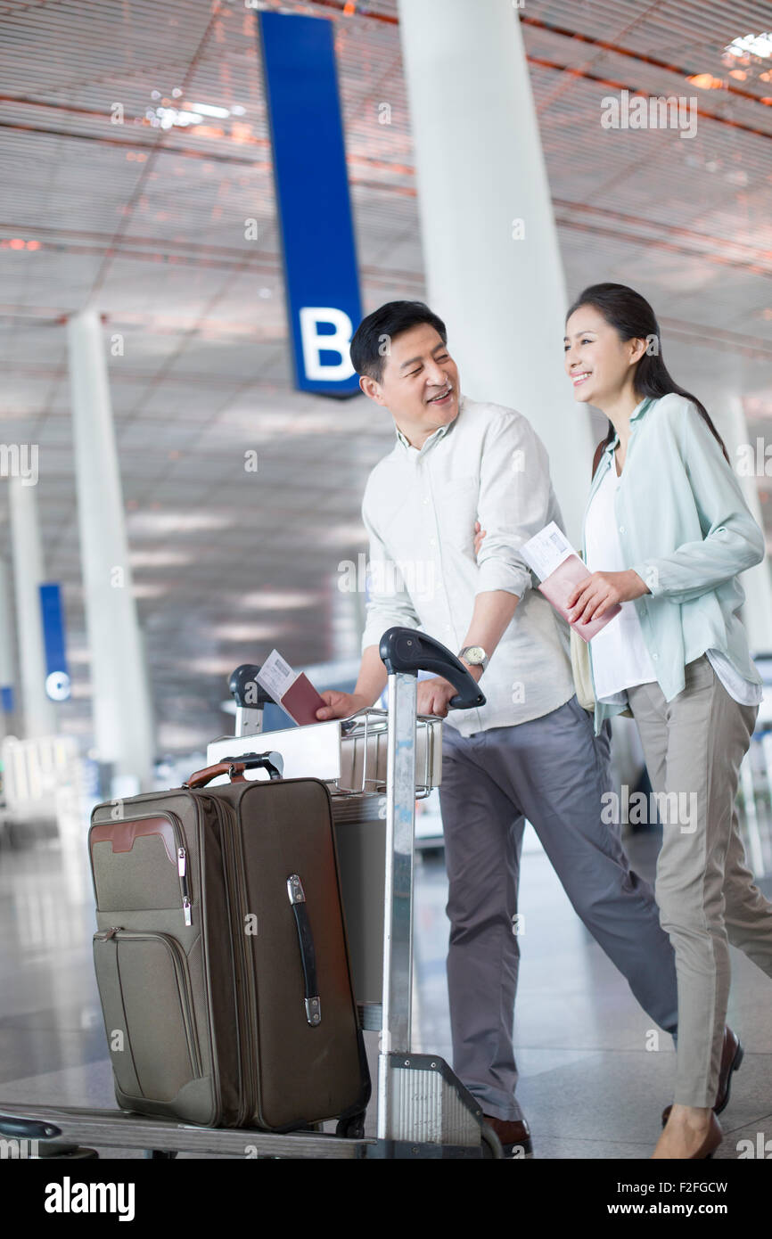 Älteres Paar zu Fuß in Flughafen mit Koffer Stockfoto