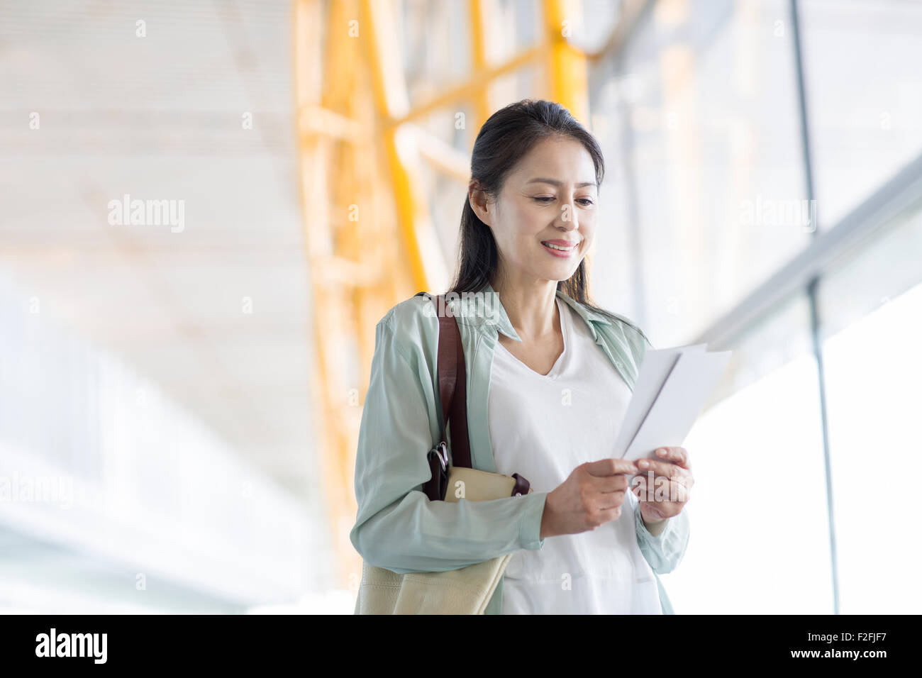 Reife Frau wartet am Flughafen Stockfoto