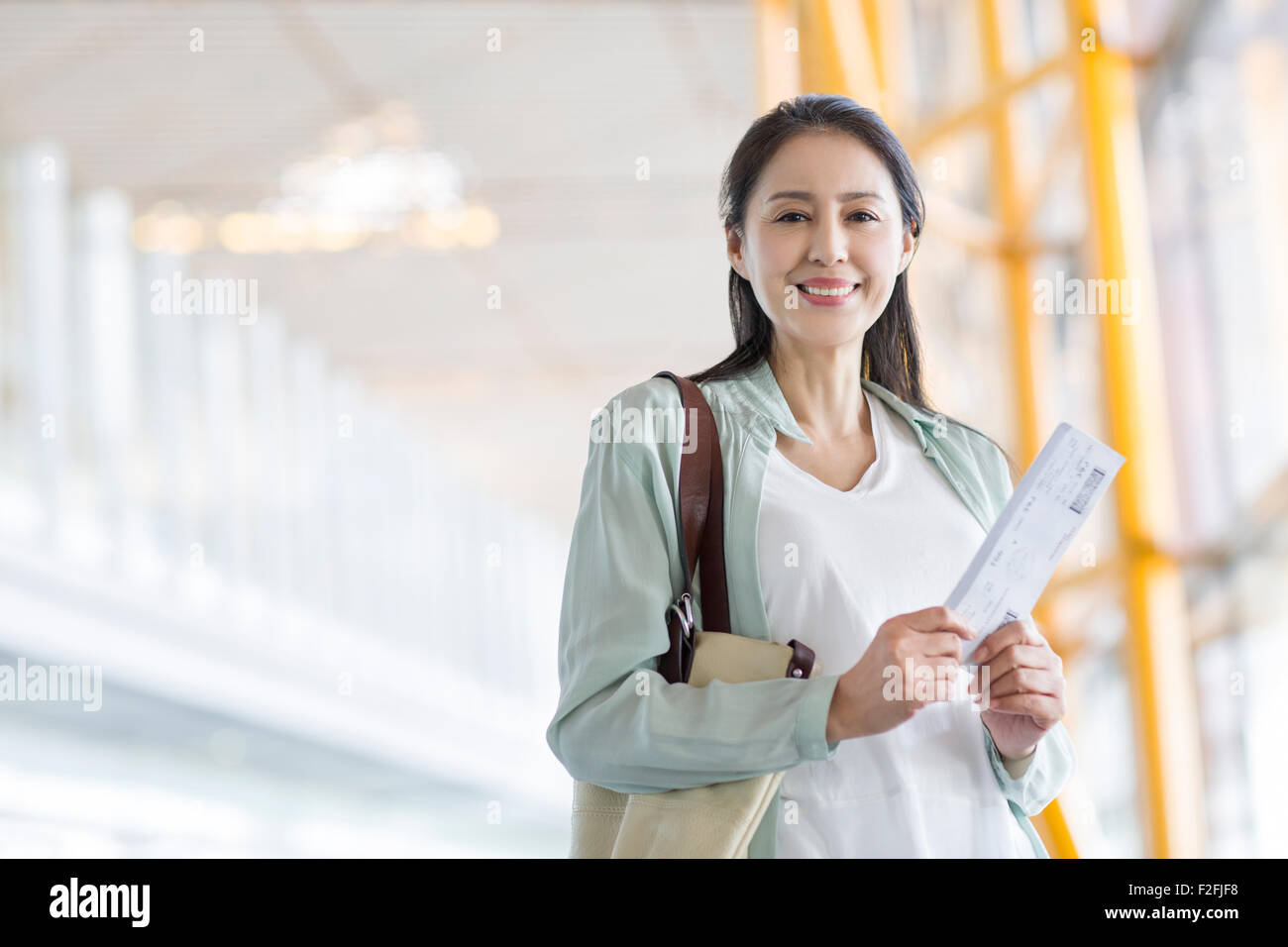 Reife Frau wartet am Flughafen Stockfoto