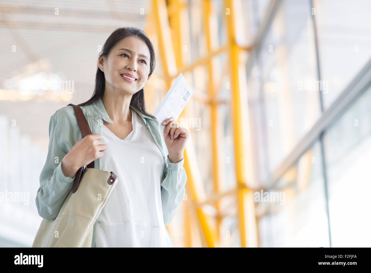 Reife Frau wartet am Flughafen Stockfoto