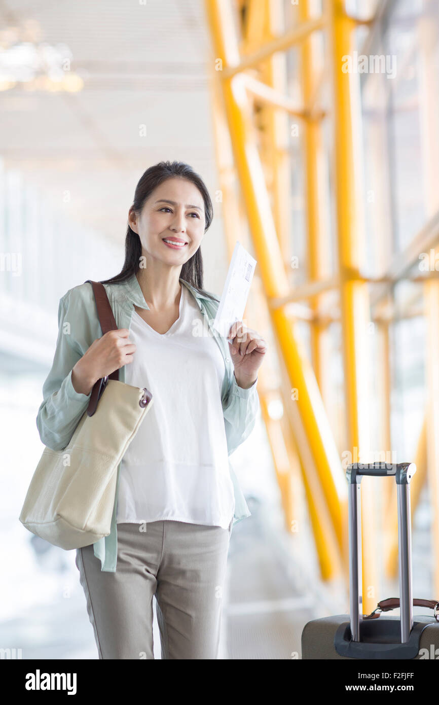Reife Frau wartet am Flughafen Stockfoto