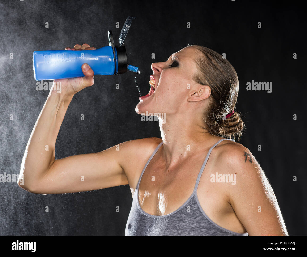 Durstig athletische Frau Trinkwasser in der Flasche Stockfoto