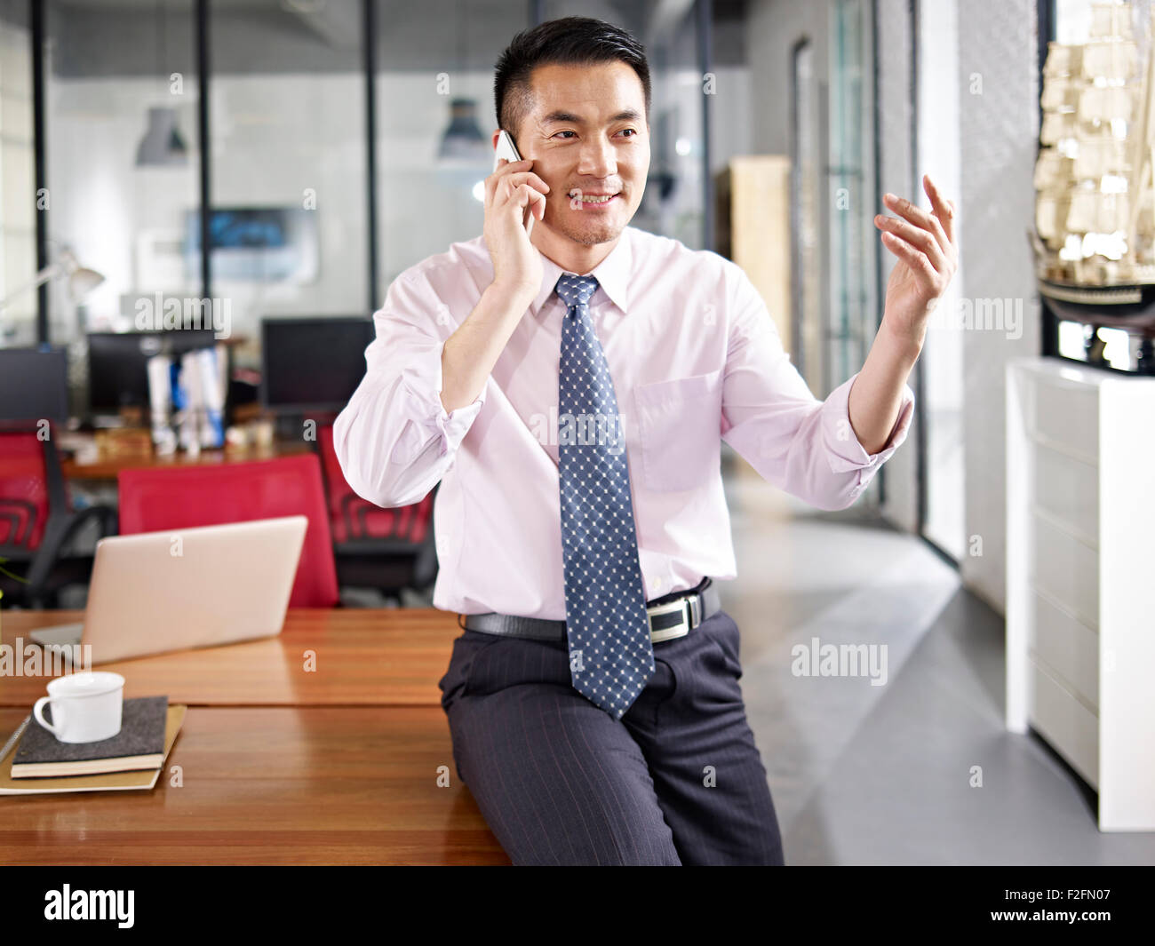 asiatische Geschäftsleute sprechen auf Handy Stockfoto