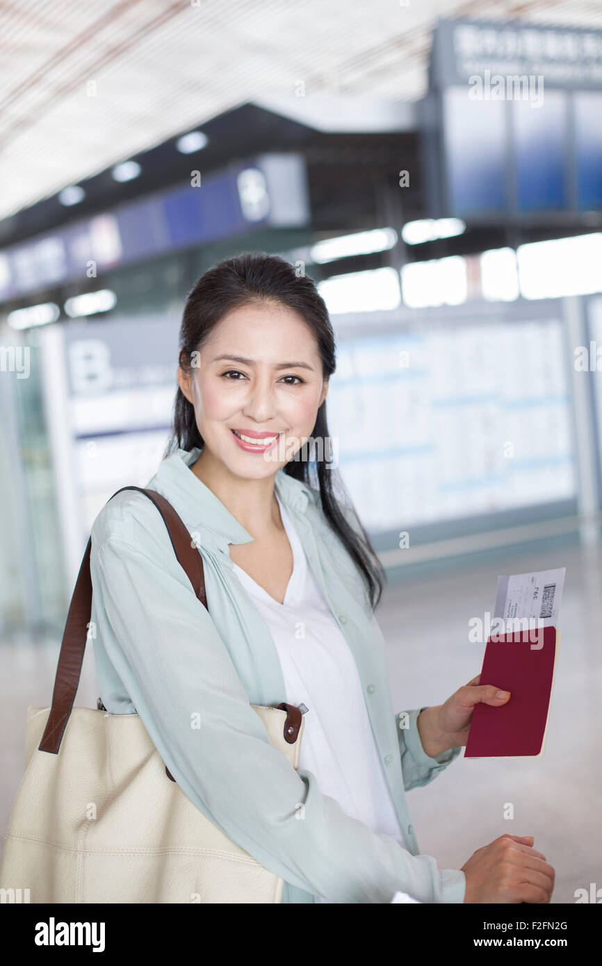 Reife Frau wartet am Flughafen Stockfoto