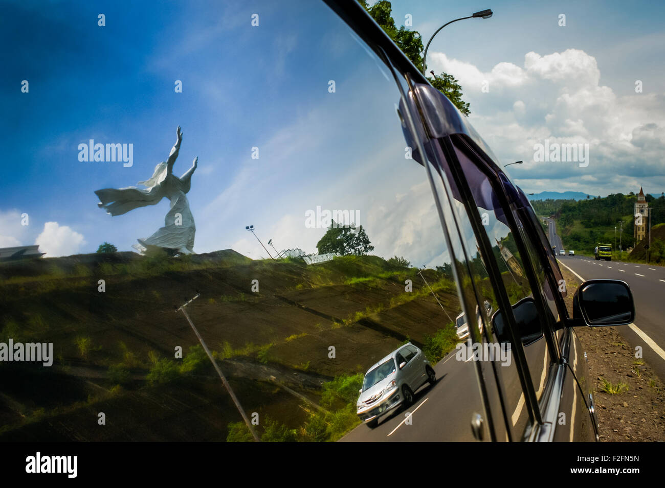 Reflexion einer riesigen Statue, bekannt als „Jesus Blessing Monument“, ein beliebtes Wahrzeichen in Manado, North Sulawesi, Indonesien. Stockfoto