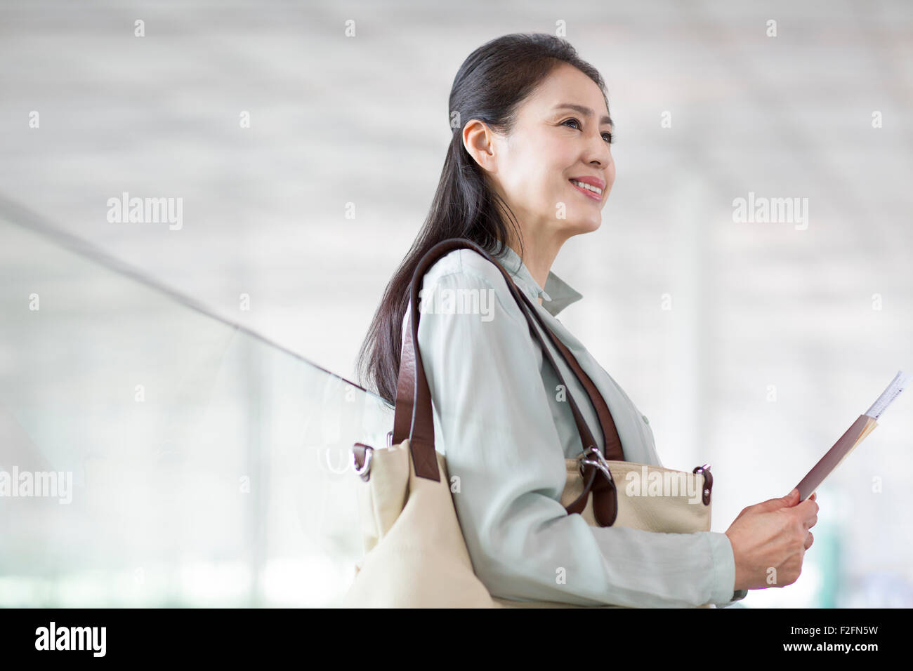 Reife Frau wartet am Flughafen Stockfoto