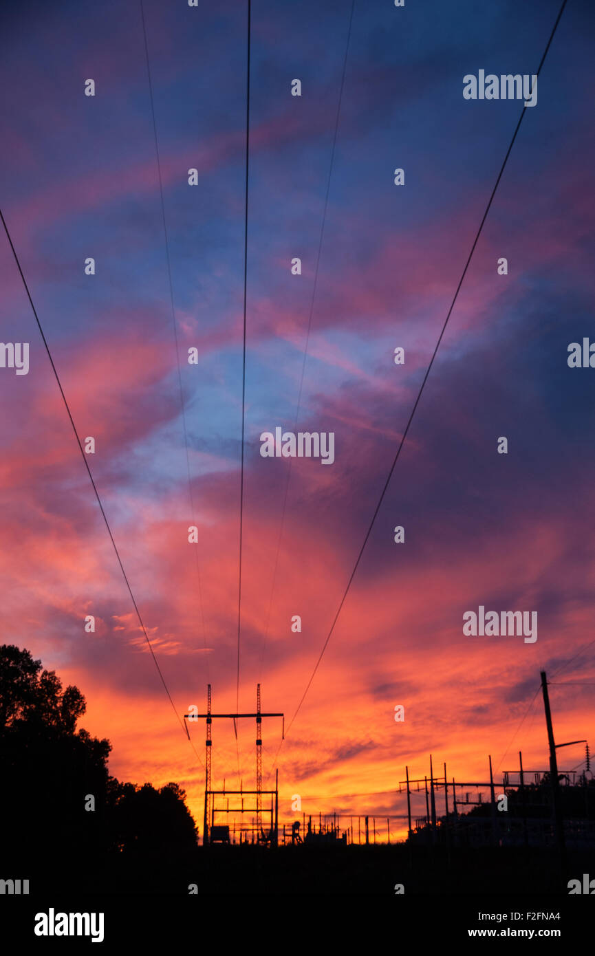Macht Übertragungsleitungen erstrecken sich von einer elektrischen Schaltanlage unter einem lebendigen Sonnenuntergang Himmel in Snellville (Metro Atlanta), Georgien. Stockfoto