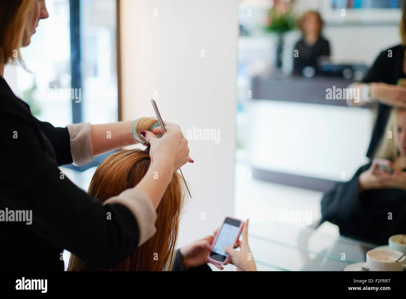 Rollen des Kunden Haare in Rollen im Salon Friseur Stockfoto