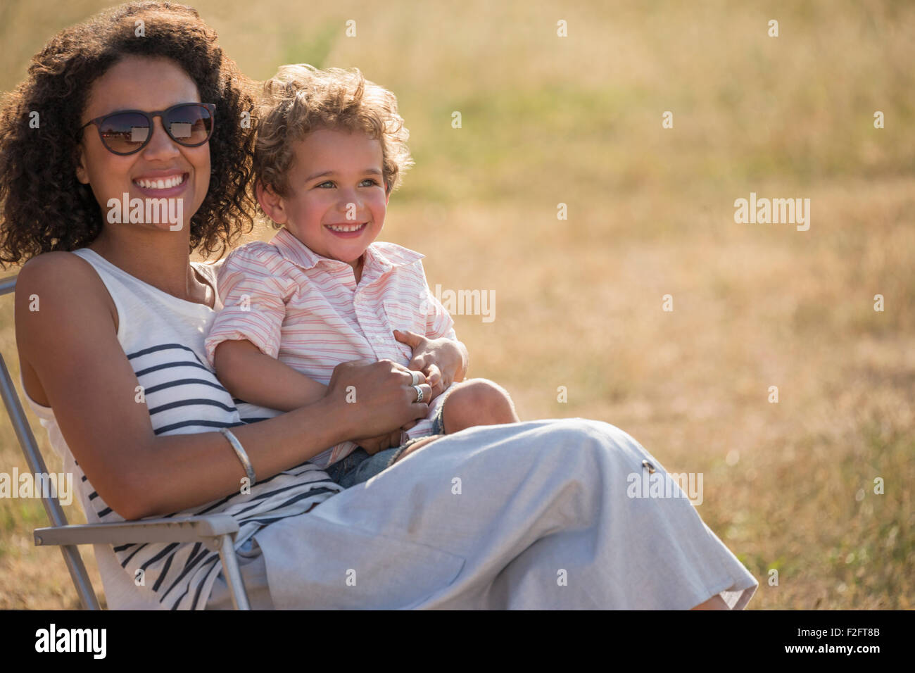 Porträt, Lächeln, Mutter und Sohn im sonnigen Feld Stockfoto