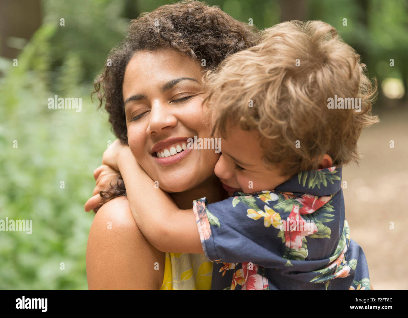 Liebevolle Mutter und Sohn umarmt mit geschlossenen Augen hautnah Stockfoto