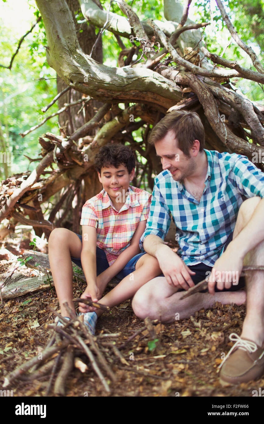 Vater und Sohn machen kleine Lagerfeuer mit Stöcken im Wald Stockfoto
