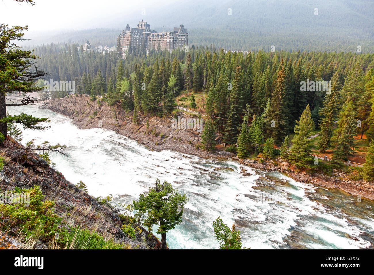 Der Bogen fällt auf den Bow River mit dem Fairmont Banff Springs Hotel im Hintergrund Banff, Alberta, Kanada Stockfoto