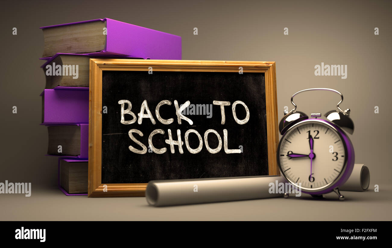 Back to School handschriftlich auf Tafel. Zeit-Konzept. Komposition mit Tafel und Stapel von Büchern, Wecker und Schriftrollen Stockfoto
