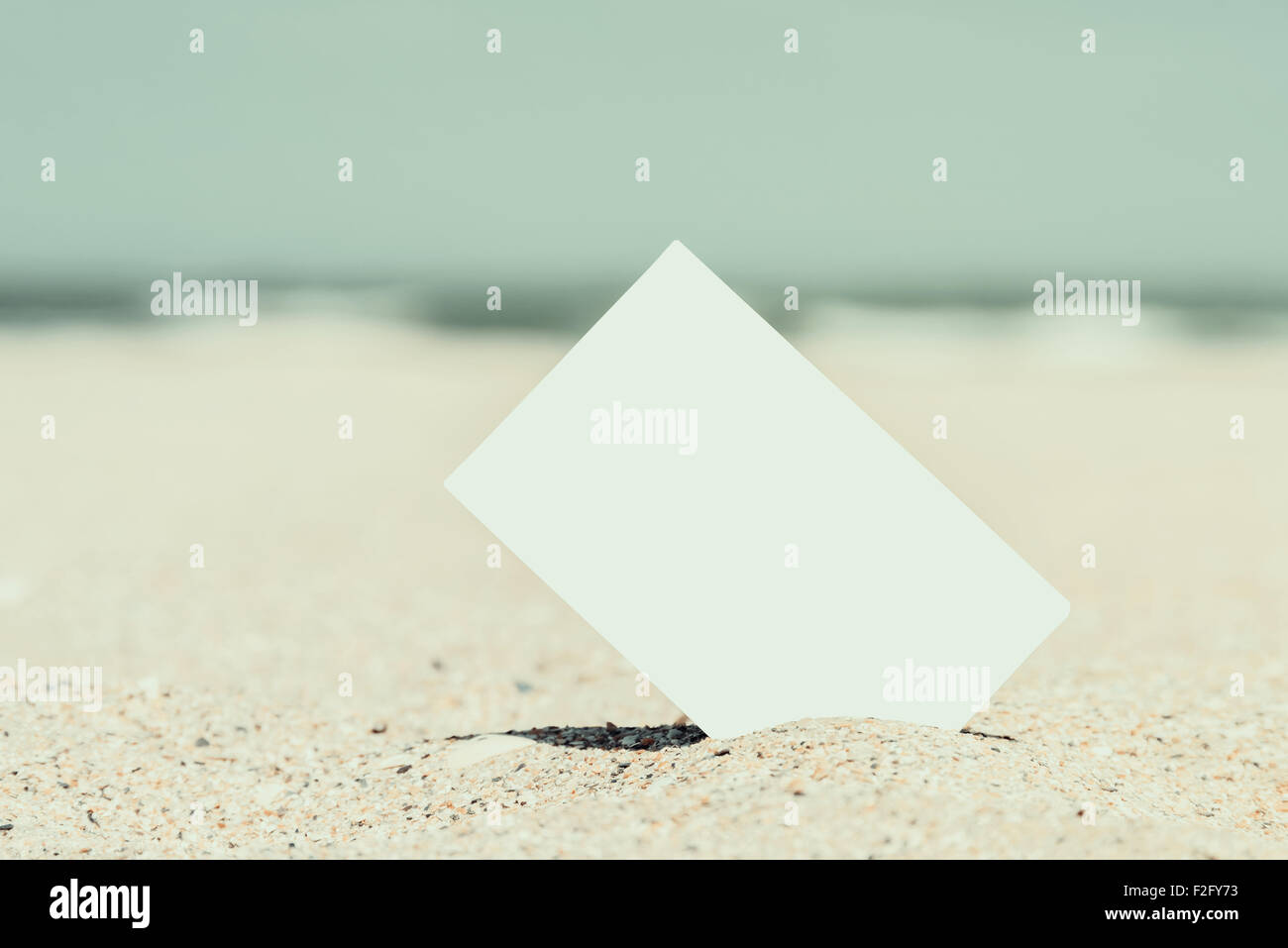 Retro-Foto von leeren Sofortbild-Karte am Strandsand im Sommer Stockfoto