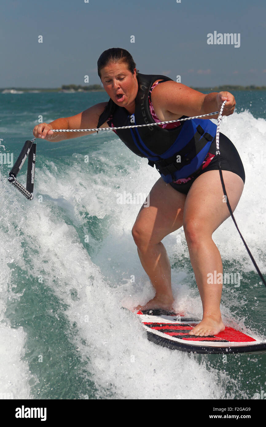 Eine Frau auf einem Boot-Folge Surfen lernen. Stockfoto