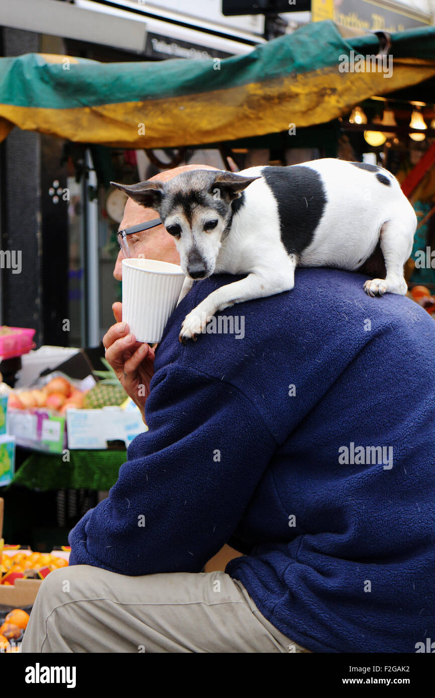 Der Portobello Market. Straßenmarkt Portobello Road in London. Stall-Inhaber mit Hund auf Schulter Stockfoto