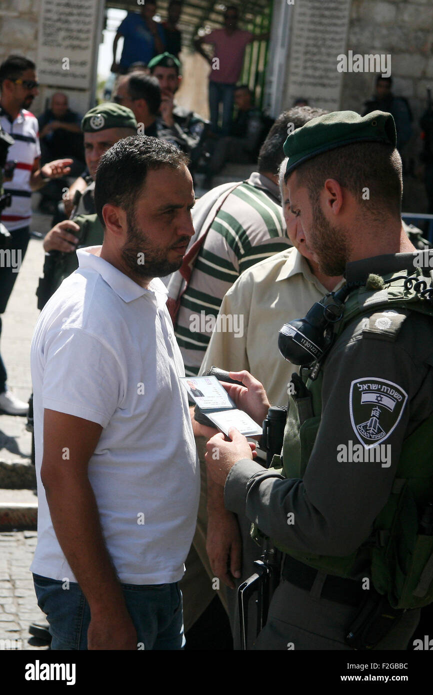 Jerusalem, Jerusalem, Palästina. 18. Sep, 2015. Ein israelische Polizisten prüft die ID von einem palästinensischen islamischen Verehrer vor dem Eintritt in die Al-Aqsa-Moschee zum traditionellen Freitagsgebet He durchführen, wie die israelische Polizei den Zugriff auf Al-Aqsa-Moschee, außerhalb der alten Stadtmauern in Ost-Jerusalem am 18. September 2015 blockiert. Israel bereitgestellt Hunderte von zusätzlichen Polizei rund um die Altstadt von Jerusalem am Freitag Bar junge muslimische Männer von gebeten an der Al-Aqsa-Moschee-Website nach dem Aufruf von palästinensischen Führer für einen "Tag des Zorns" Protest gegen neue israelische Sicherheitsmaßnahmen (Credit-Bild: © Mahfo Stockfoto